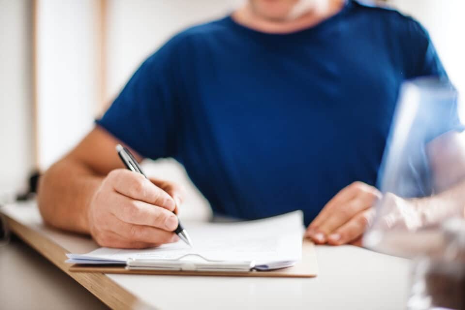 Man filling out an application to get a Colorado Public Defender