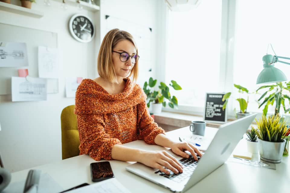 Professional woman sitting at a desk working on a laptop